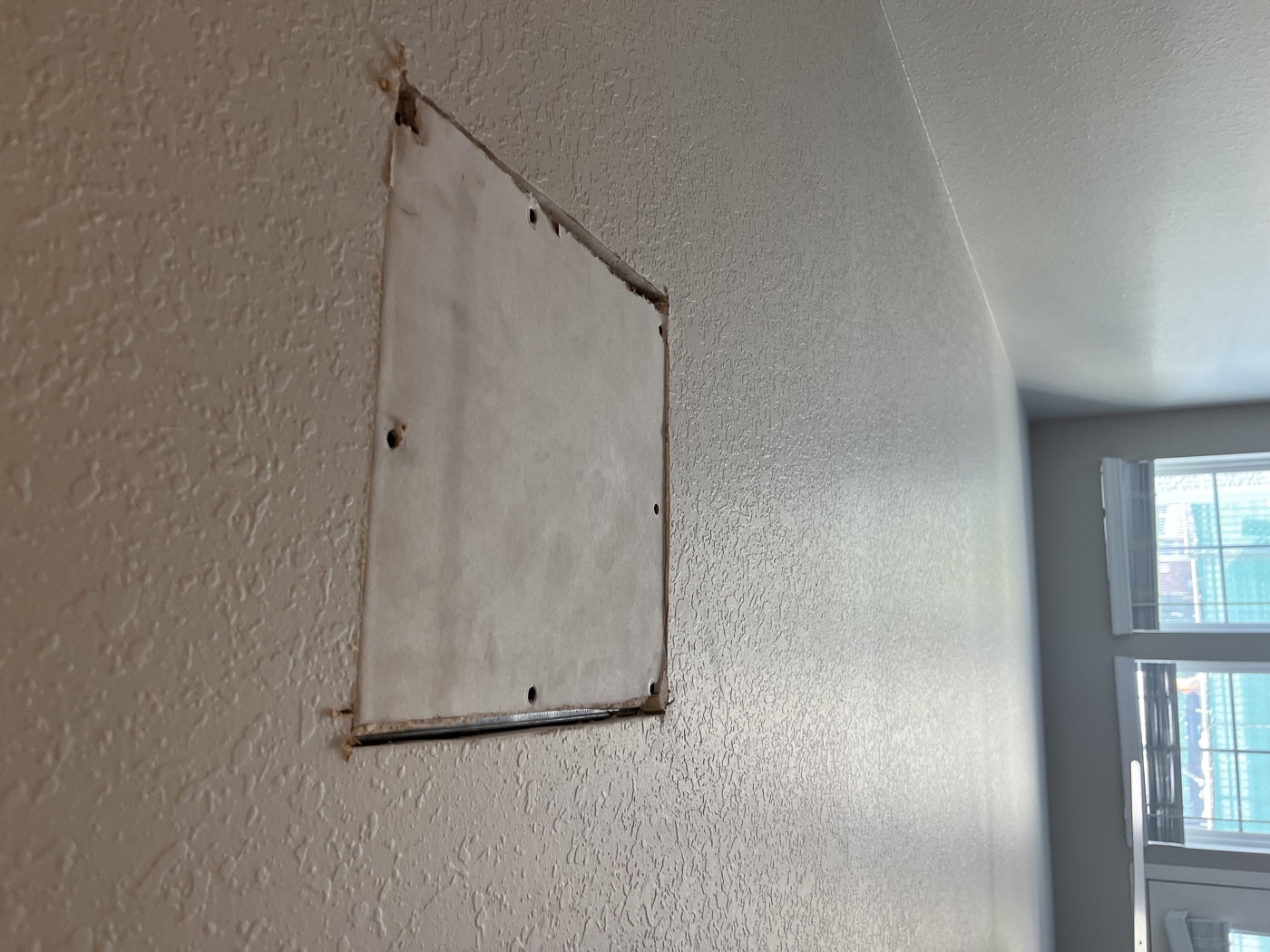Bare drywall patch, taped and prepped before painting